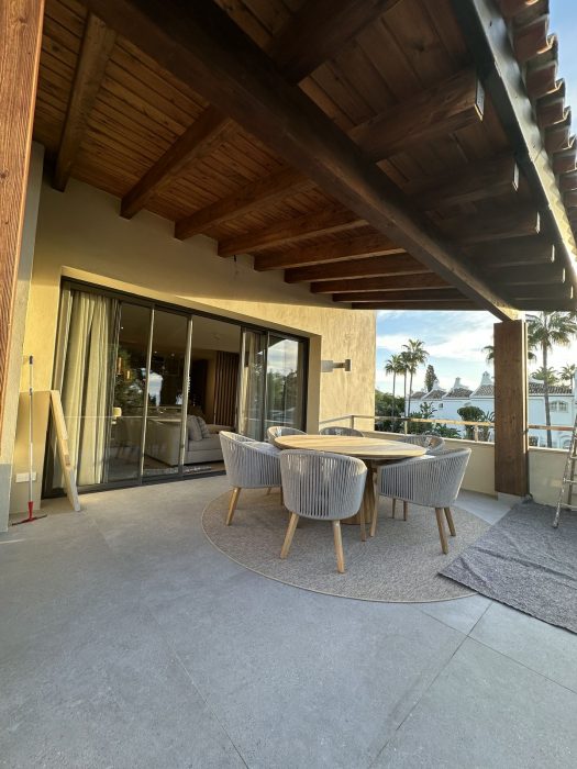 Terraza terminada del piso de lujo, con el techo de madera y el mobiliario puesto