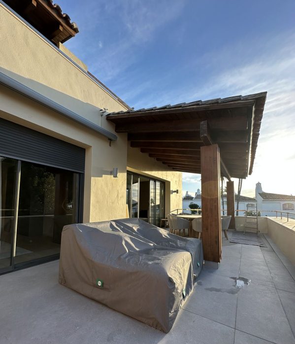 Terraza terminada del piso de lujo, con el techo de madera y el mobiliario puesto