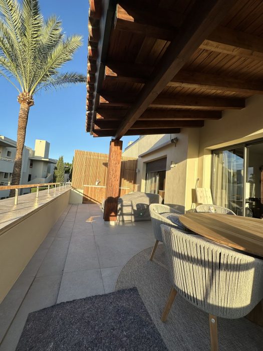 Terraza terminada del piso de lujo, con el techo de madera y el mobiliario puesto