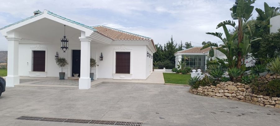Fachada con molduras terminada en la entrada, con el porche de columnas